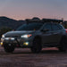 Rigid Industries SR-Series 20in SAE Driving Light Amber parked at dusk in dirt lot.