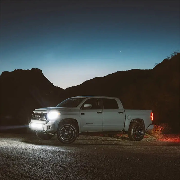 White truck on side of road at night with SAE compliant lights