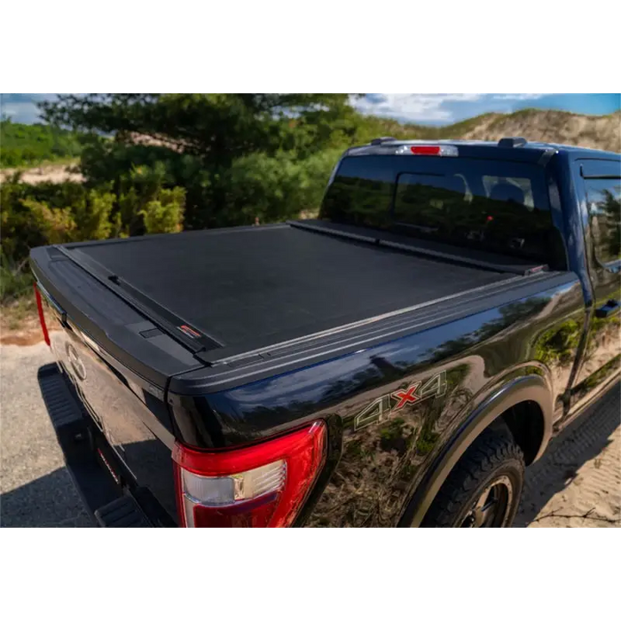 Black truck bed cover for 16-18 Toyota Tacoma with Roll-N-Lock design.