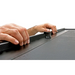 Roll-N-Lock truck bed cover: Man’s hand holding black plastic sheet.