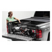 Woman loading truck bed with tool in Roll-N-Lock Toyota Tacoma Cargo Manager