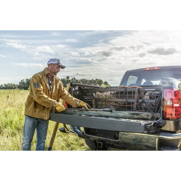 Man in yellow jacket loads truck with tool for Roll-N-Lock Cargo Manager installation.