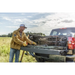 Man in yellow jacket loads truck with tool for Roll-N-Lock Cargo Manager installation.