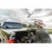Man in hat fixing truck hood with Roll-N-Lock Cargo Manager for Toyota Tacoma installation instructions