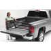 Woman loading Roll-N-Lock Cargo Manager in Toyota Tacoma truck bed