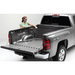 Woman loading bed of Roll-N-Lock Toyota Tacoma with Cargo Manager.