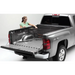 Woman loading bed of truck with Roll-N-Lock Cargo Manager for Toyota Tacoma.