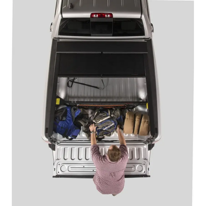 Man installing Roll-N-Lock Cargo Manager in Toyota Tacoma Crew Cab SB - Installation Instructions