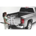 Woman loading Roll-N-Lock Toyota Tacoma Cargo Manager in truck bed