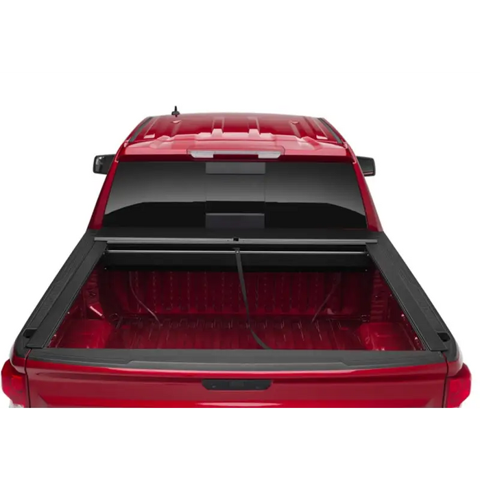 Red car with open trunk lid, Roll-N-Lock retractable truck bed cover for Toyota Tacoma Crew Cab SB.