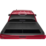 Red truck bed cover open on Toyota Tacoma with Roll-N-Lock design.