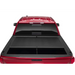 Red truck bed cover open on Toyota Tacoma with Roll-N-Lock design.