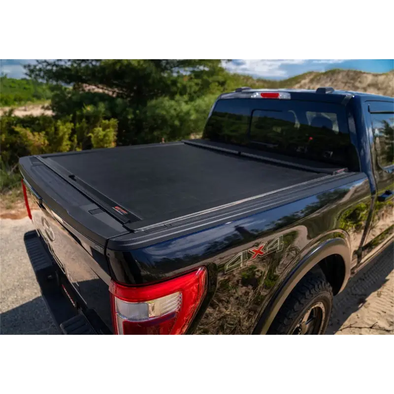 Roll-N-Lock retractable tonneau cover on black truck bed with cover