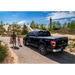 Father and daughter walking towards black truck with Roll-N-Lock 16-18 Toyota Tacoma Crew Cab SB M-Series Retractable Tonneau Cover.