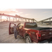 Man loading gravel onto truck bed with Roll-N-Lock A-Series Retractable Tonneau Cover