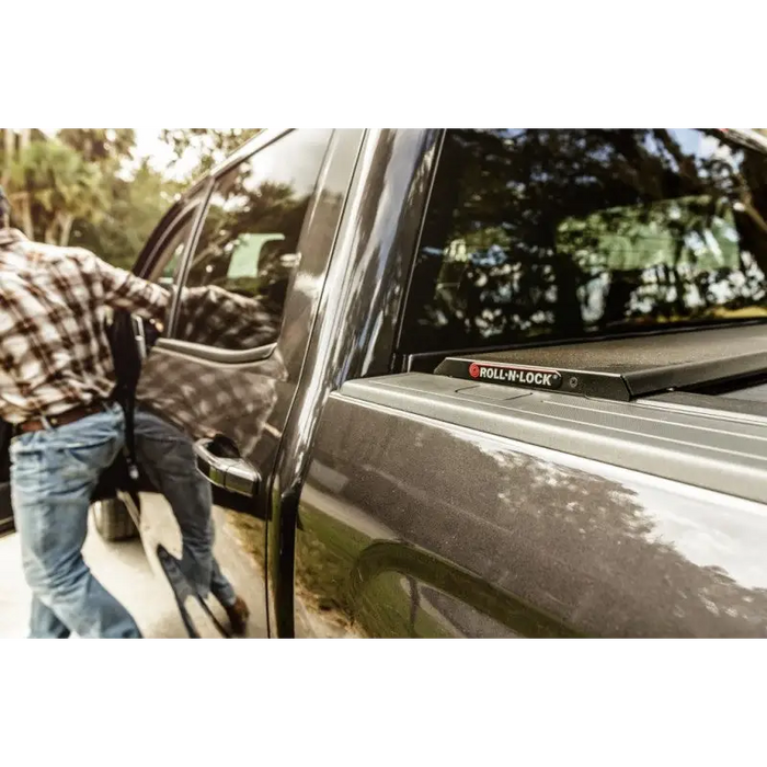 Man walking towards a truck with Roll-N-Lock retractable tonneau cover.