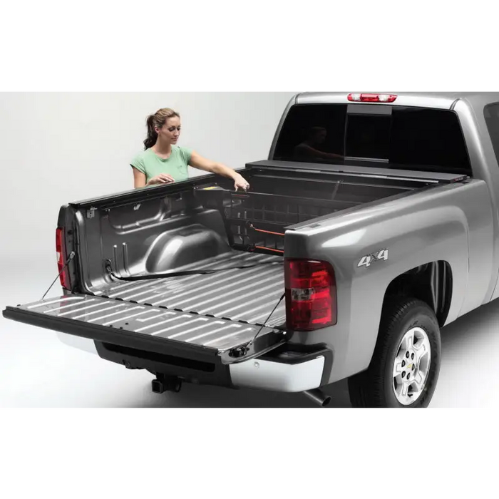 Woman loading truck bed with Roll-N-Lock 20-22 Jeep Gladiator Cargo Manager.