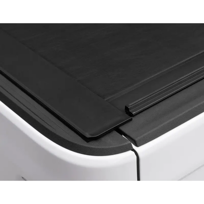 Roll-N-Lock retractable tonneau cover on black plastic door of truck bed