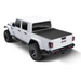 Roll-N-Lock Retractable Tonneau Cover for 2020 Jeep Gladiator with white truck bed, black top, and wheels