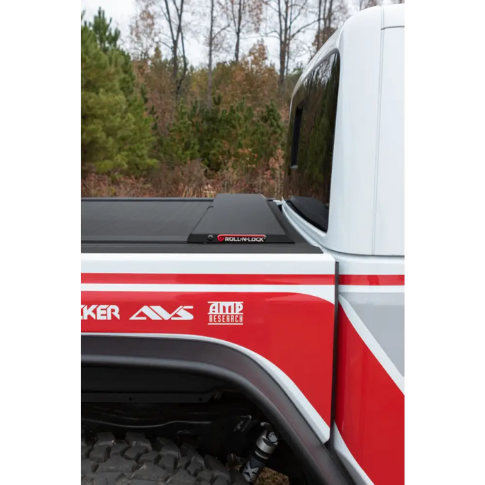 Red and white truck with the word ’kf’ on it, showcased in Roll-N-Lock 2020 Jeep Gladiator 5ft bed M-Series retractable ton