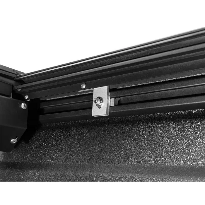 Roll-N-Lock truck bed cover with black steel frame mounted on wall.