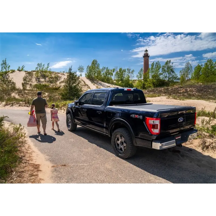 Man and girl walking towards black truck bed cover - Roll-N-Lock 2020 Jeep Gladiator.
