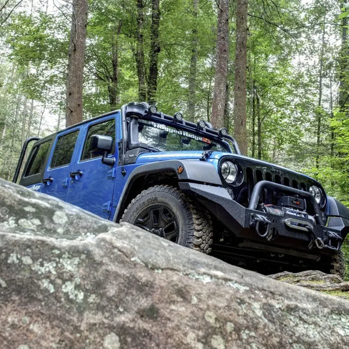 Blue Jeep parked on rock in woods with Rugged Ridge XHD Snorkel pre-filter