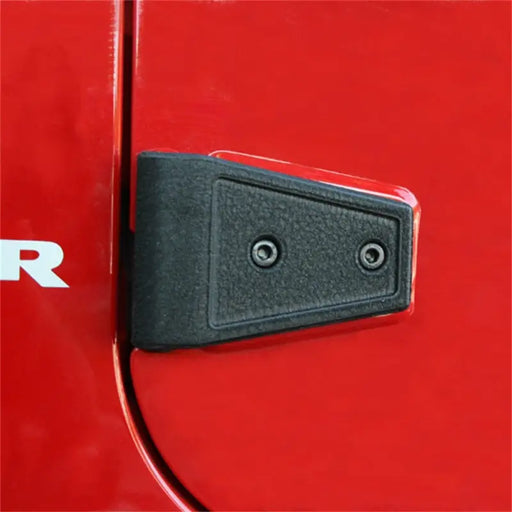 Rugged Ridge textured black door hinge cover kit for Jeep Wrangler with red car door.