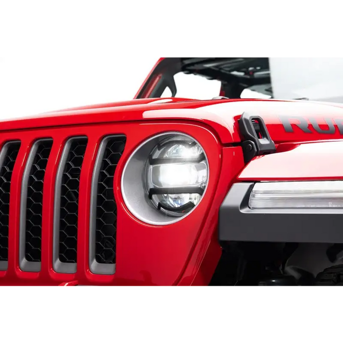 Red Jeep with headlight guards displayed on white background.