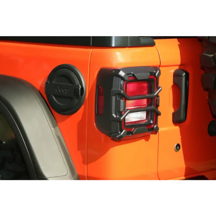 Rugged Ridge 18-20 Jeep Wrangler JL Elite Tail Light Guard featuring front end of a jeep with red light.