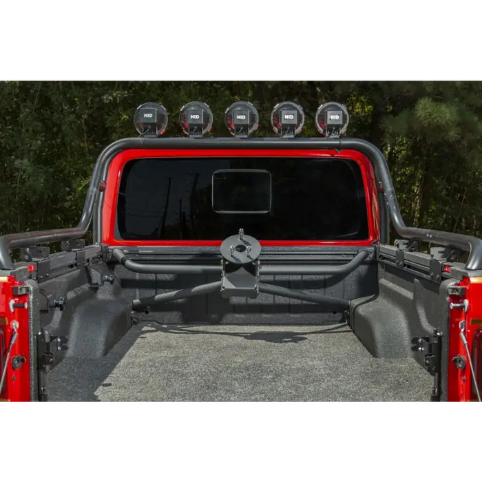 Rugged Ridge Jeep Gladiator JT Spare Tire Carrier featuring rear view of red jeep with front bumper mounted on.