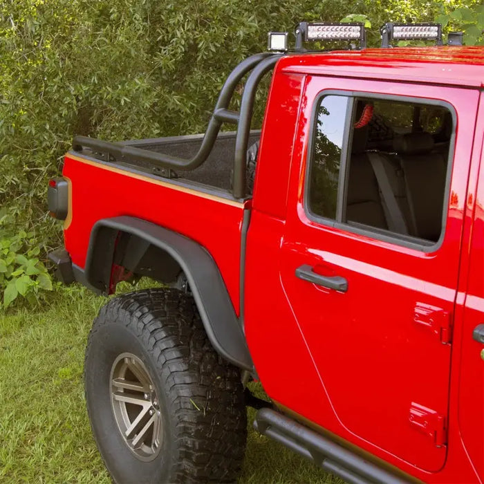 Rugged Ridge steel tube fender kit on red truck parked in grass