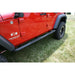 Red Jeep parked on grass next to black tire - Rugged Ridge 3 Inch Round Tube Steps Black 07-18 Jeep Wrangler Unlimited JK