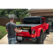 Man loading truck bed with Armis Hard Folding cover by Rugged Ridge