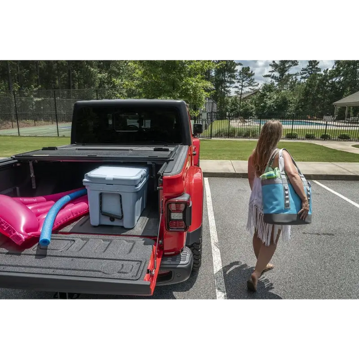 Woman walking towards red truck with cooler, Armis Hard Folding bed cover 2020 JT.