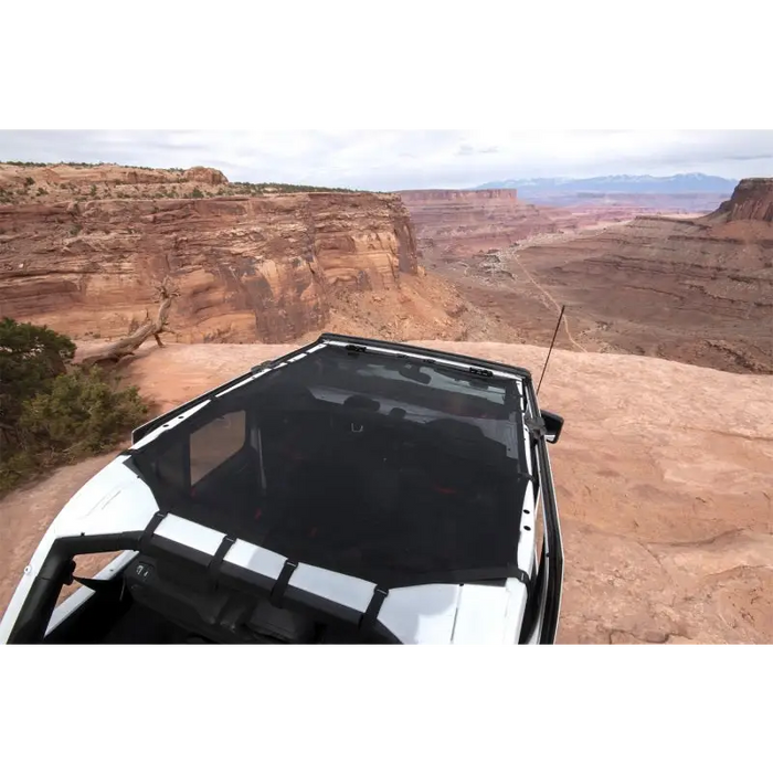 Off-road jeep with Rugged Ridge Eclipse Sun Shade driving on rocky terrain