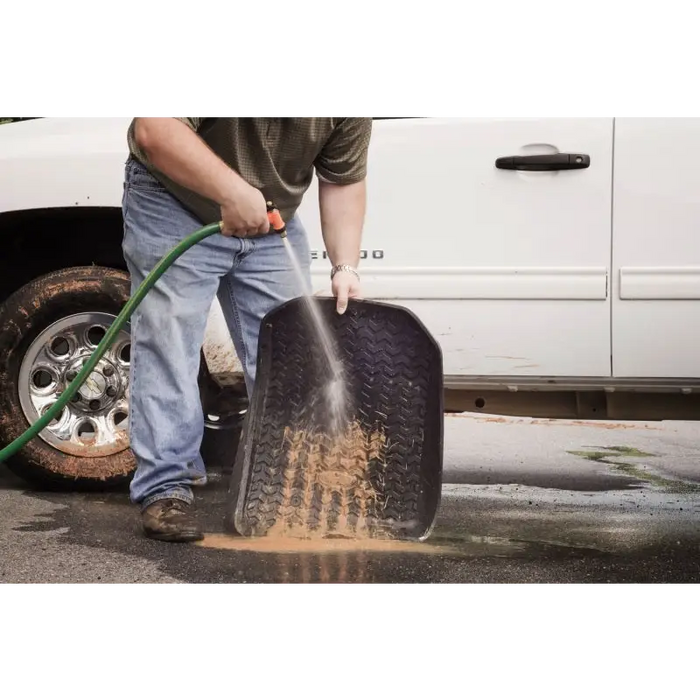 Man using a tire to clean a Rugged Ridge floor liner on a Jeep Wrangler.