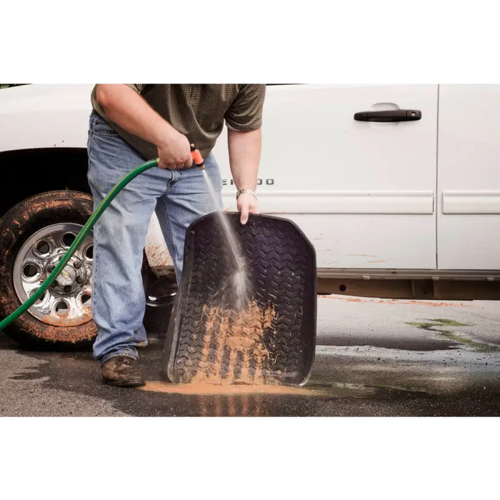 Man hosing tire on Rugged Ridge Floor Liner Cargo Black for Jeep Logo Cherokee XJ.