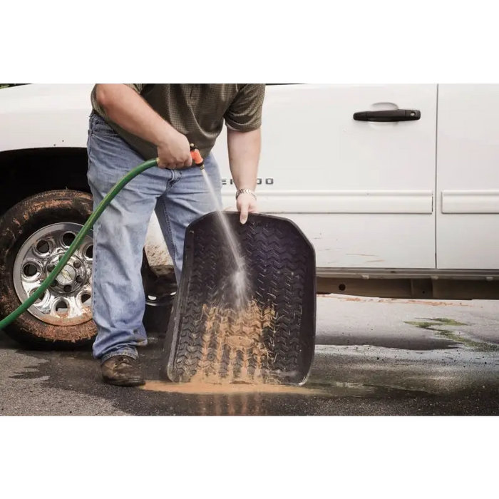 Man cleaning tire with a sturdy Rugged Ridge floor liner for Jeep Cherokee XJ