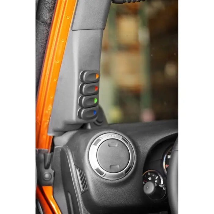 Interior of a Jeep Wrangler with door handle open, showcasing Rugged Ridge A-Pillar 4 Switch Pod Kit in Black.