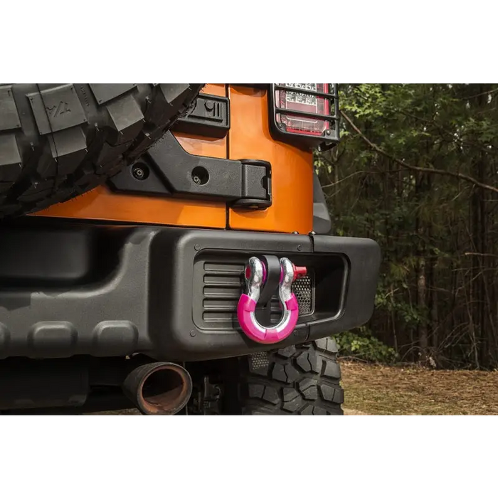 Rugged Ridge pink 3/4in D-ring isolator kit front bumper mount on a person.
