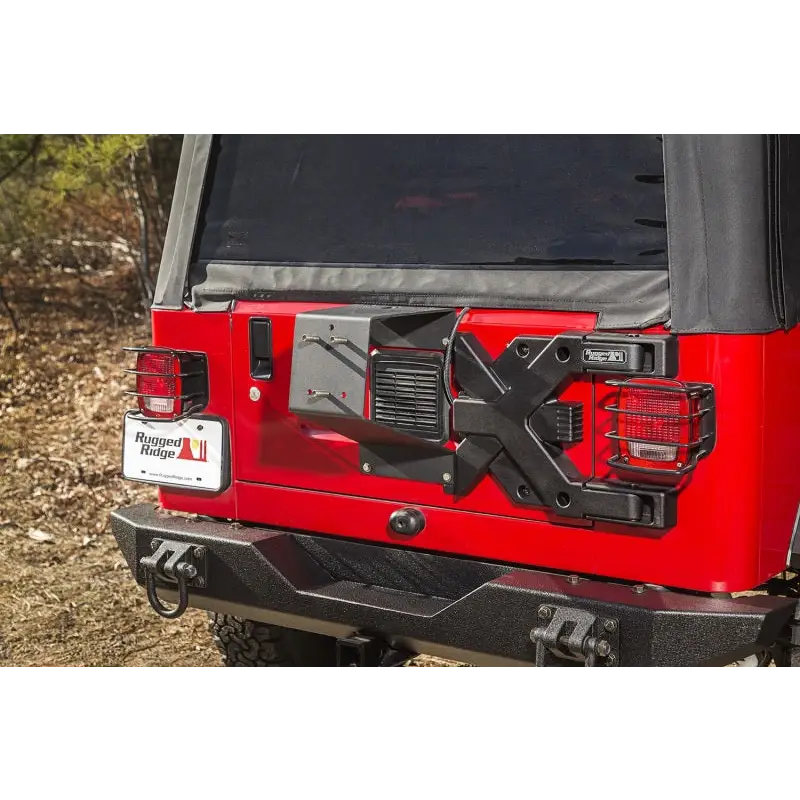 Red Jeep with black top parked in dirt - Rugged Ridge Spartacus HD Tire Carrier Hinge Casting 97-06 TJ
