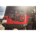 Red Jeep with black top parked on road, showcasing Rugged Ridge Spartacus HD Tire Carrier Kit.