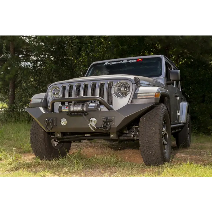 Rugged Ridge Spartan Front Bumper HCE W/Overrider on Jeep Wrangler in Field.