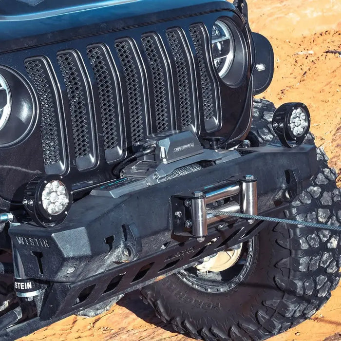 Jeep being lifted by 10000 LBS 12V DC winch with wire rope.