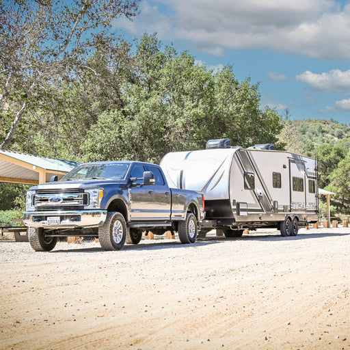 Ford super duty diesel leveling system with truck towing camper on dirt road