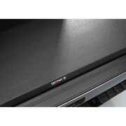 Black Truxedo Bed Cover with Company Logo on Laptop