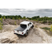 Truck driving on dirt road with Truxedo 2020 Jeep Gladiator 5ft Lo Pro bed cover.