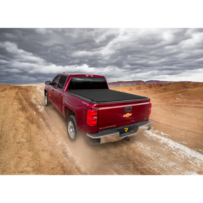 Red truck driving down dirt road with Truxedo Pro X15 Bed Cover