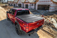 Red truck parked in front of house under construction - undercover 16-20 toyota tacoma 5ft armor flex bed cover